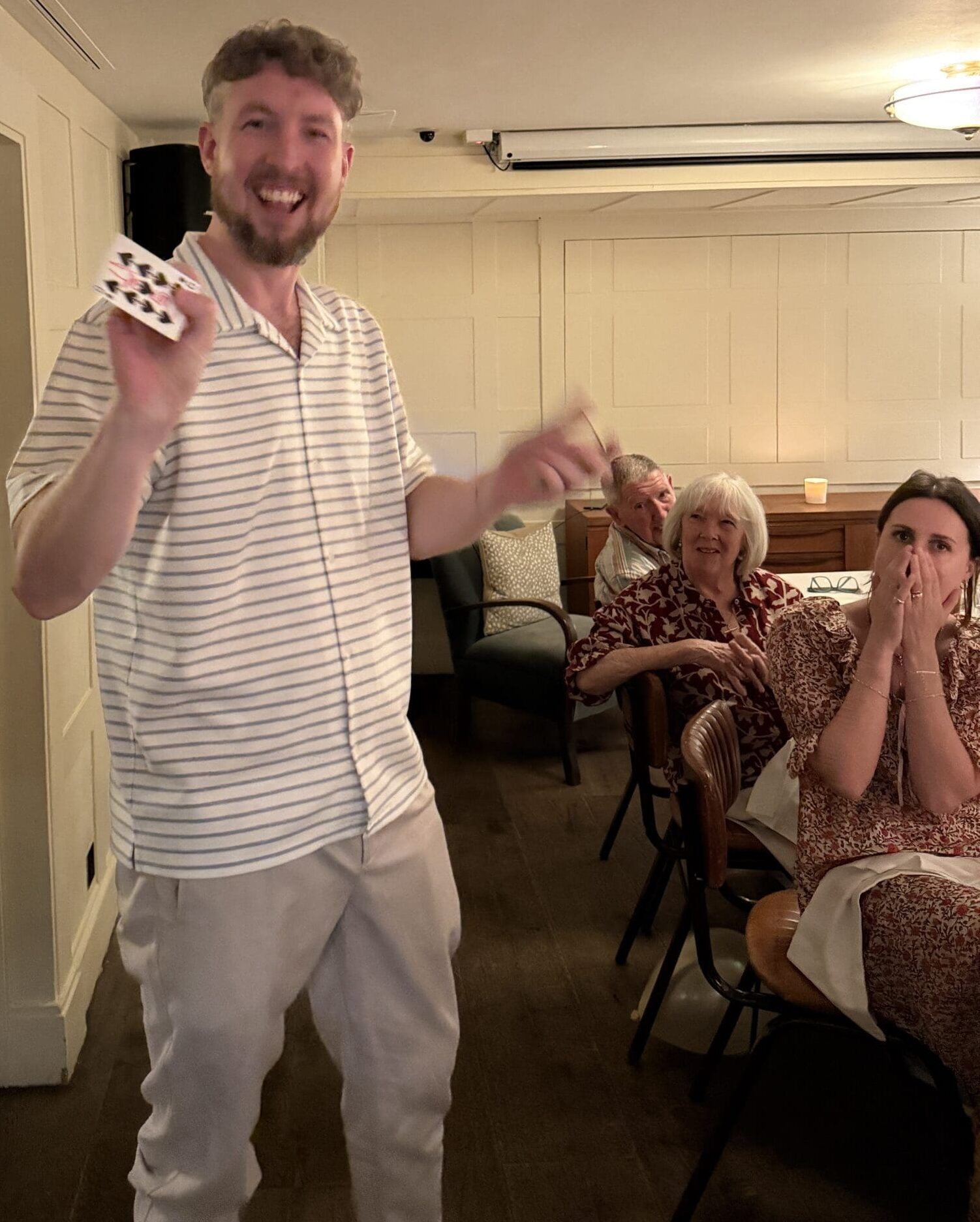 Liam Ball 'The Gentleman Magician' performing a close-up card magic trick with the 9 of Spades for engaged guests at High Road House, Chiswick, London