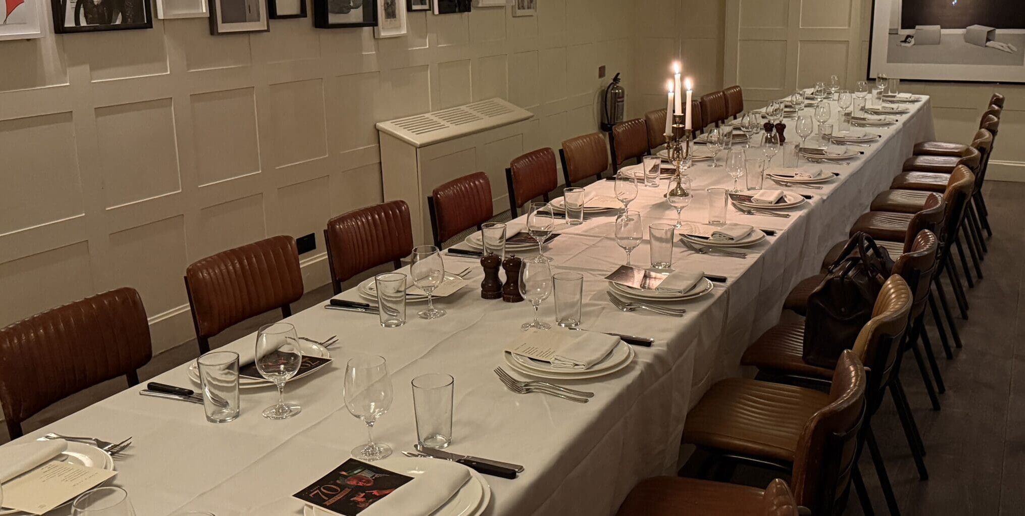 The empty private dining room downstairs at High Road House in Chiswick set up for an intimate event with a long white table.